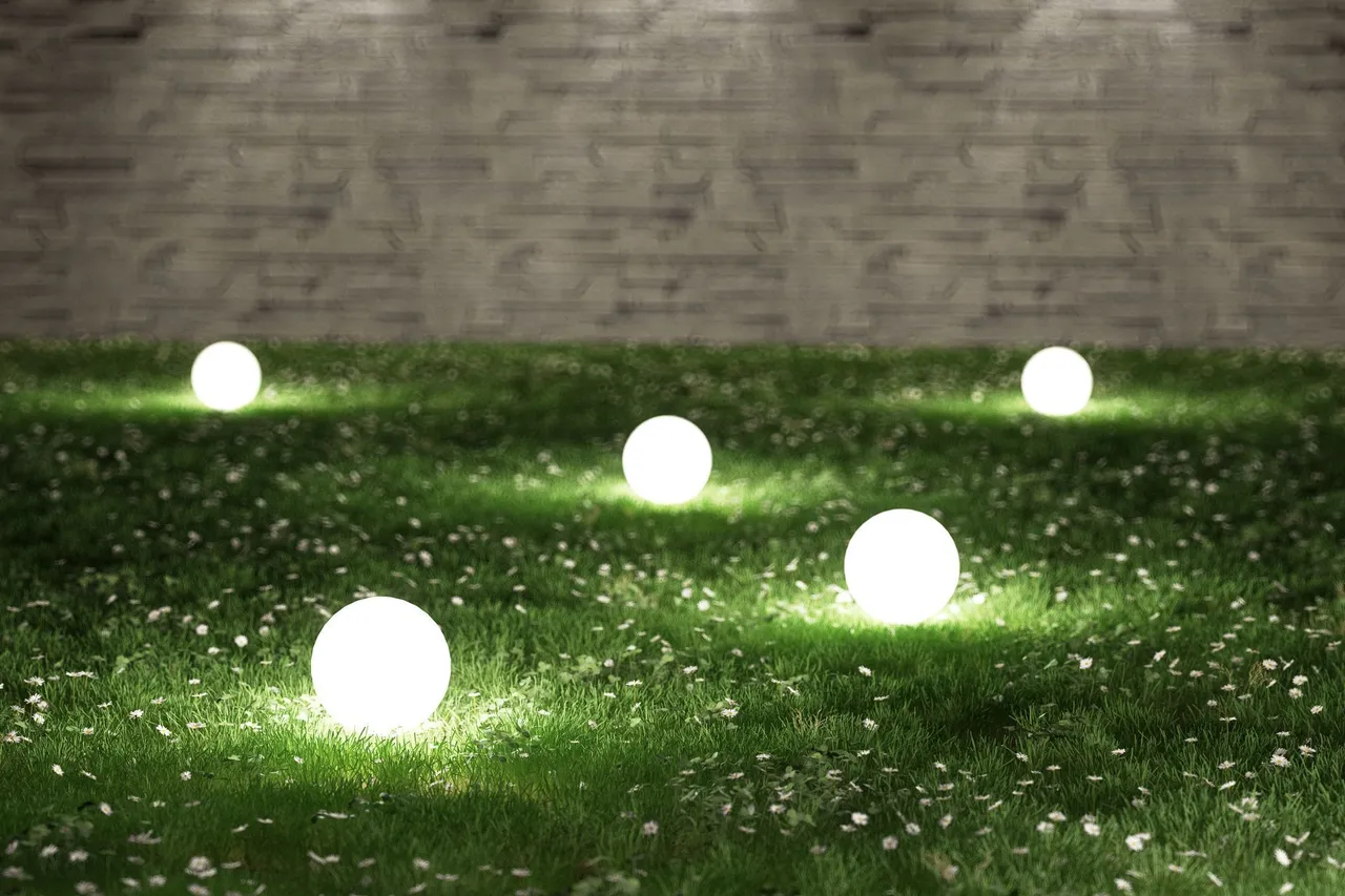 Five glowing orbs illuminate a grassy lawn, set against a brick wall.